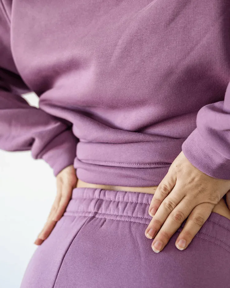 Person holding their lower back in discomfort