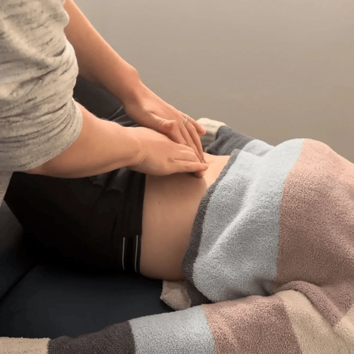 Physical therapist performing manual abdominal therapy